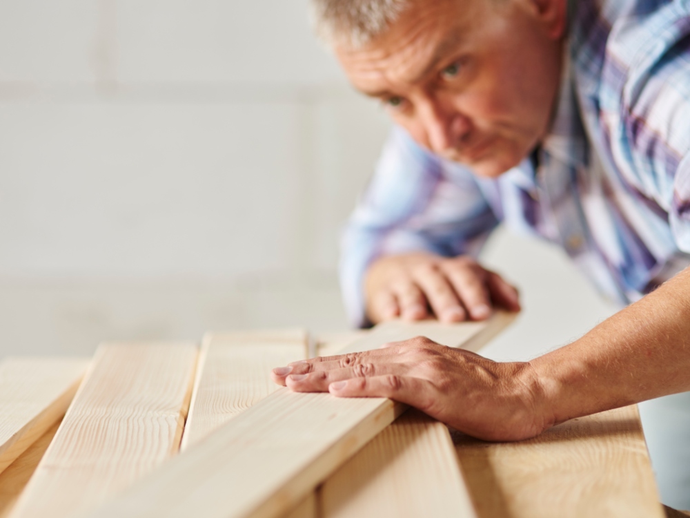 Hombre realizando un control de calidad en tablas de madera
